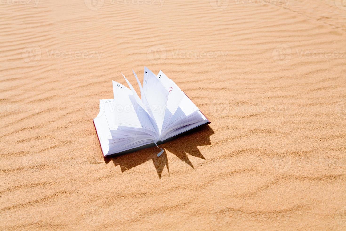 cuaderno en el desierto de dunas de arena foto