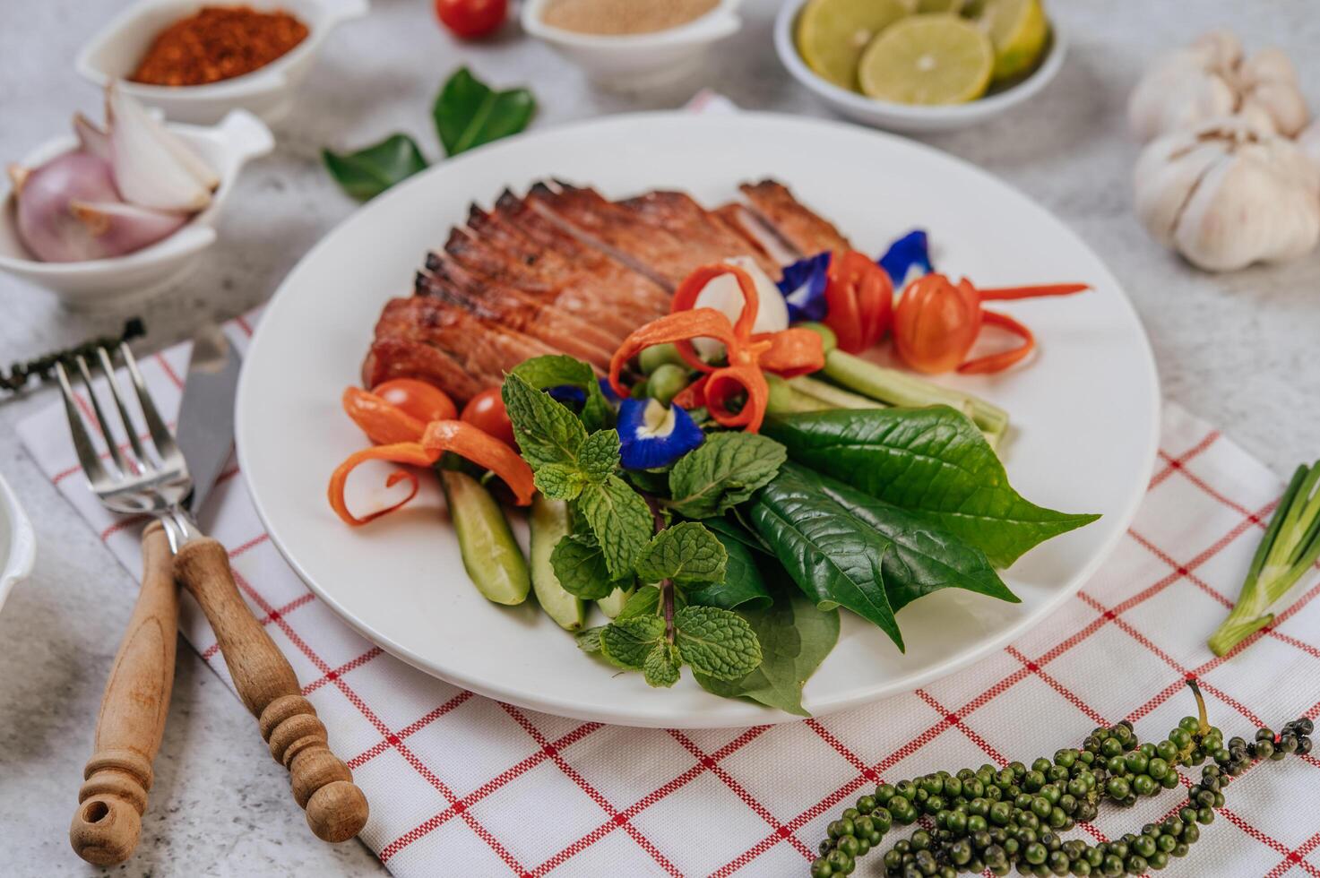 Pork with lemon, onion, red onion, tomato, long bean, butterfly pea flower, and mint. photo