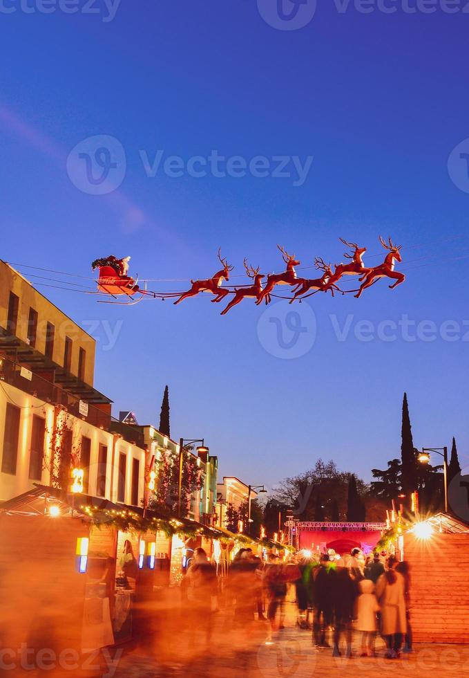 Street view crowds of people with children on xmas market on Christmas day. Celebrations and city holidays spirit photo