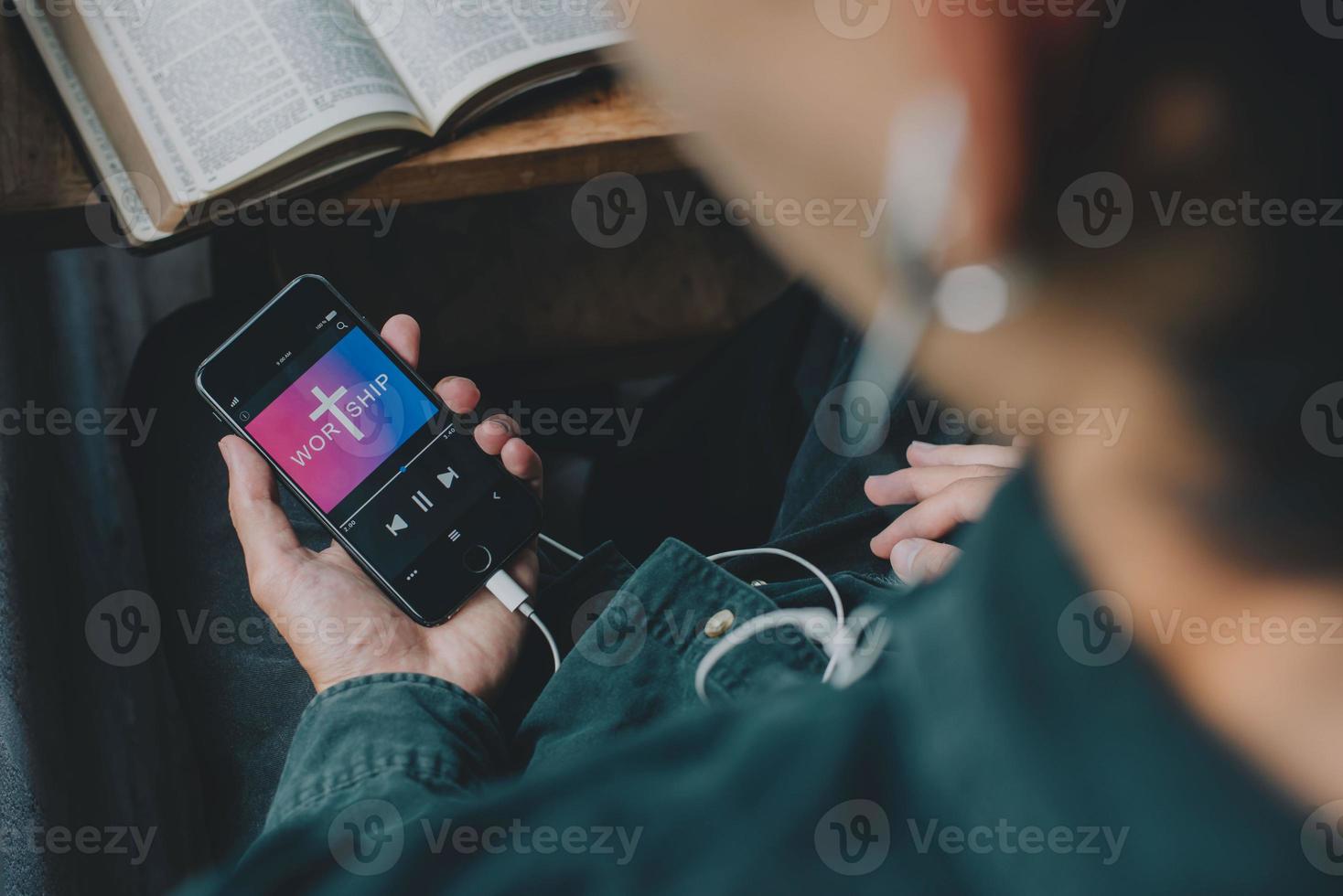 Man holding mobile phone praying worship to GOD with church online Sunday at home. Quarantine from Covid-19 Coronavirus pandemic. spirituality religion online concept photo