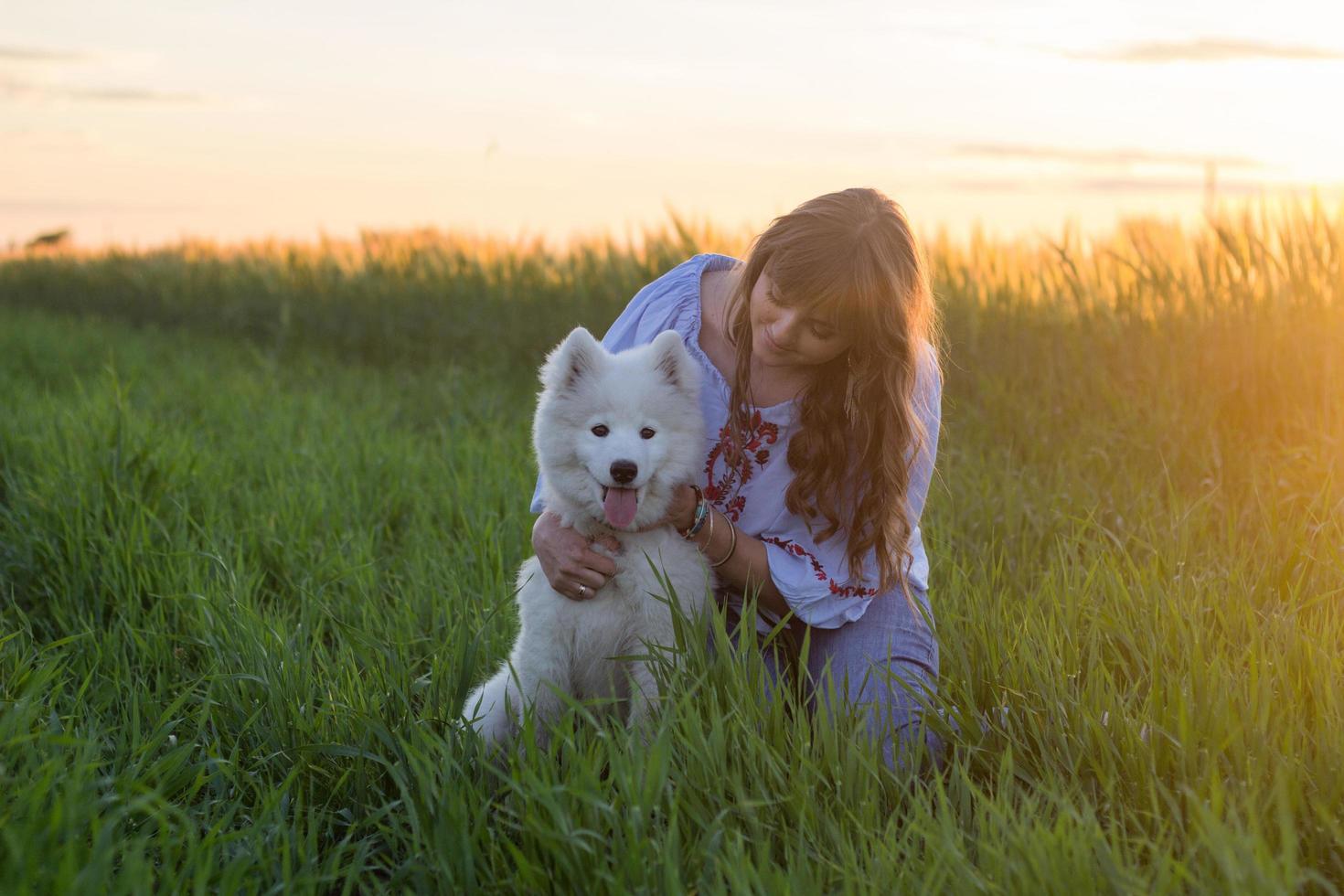 portrait of woman and white puppy of husky dog in the fields photo