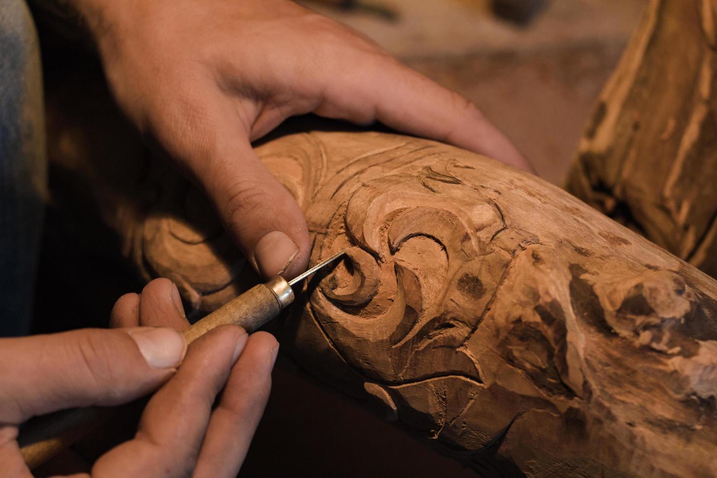 close up picture of woodcarver at work, handcrafting with wood photo