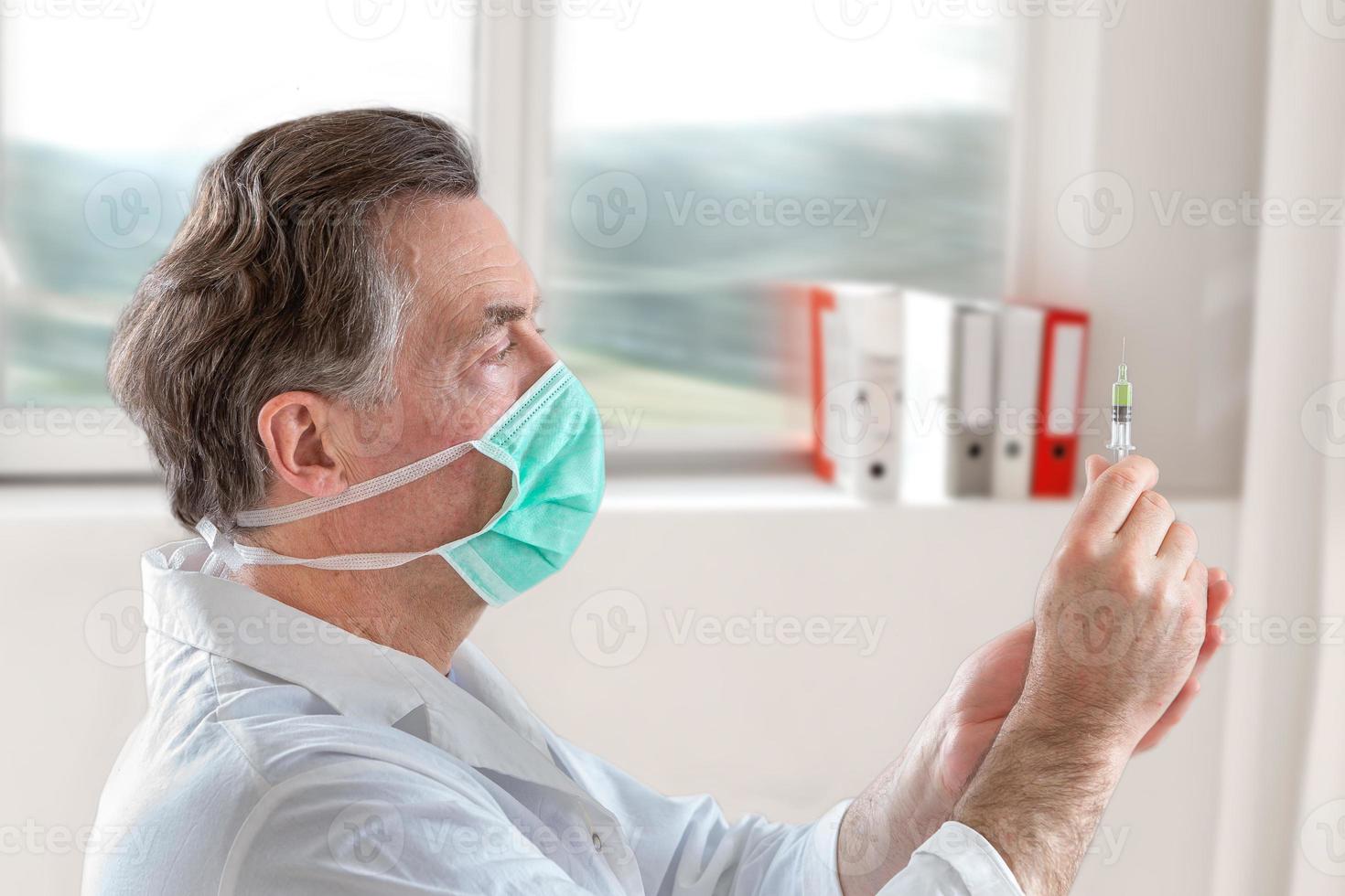 The doctor fills a syringe with vaccine on blurred background. photo