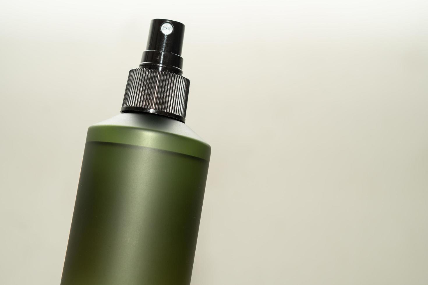 Green cosmetic bottle with label isolated on white background. Close up aroma spray bottle. Concept of organic cruelty free. Natural organic spa cosmetics concept. photo