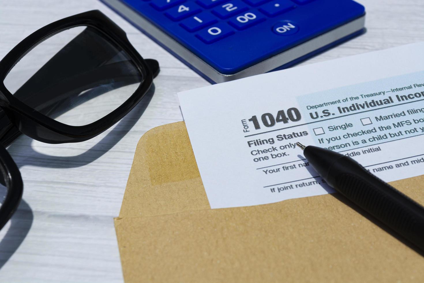 formularios de impuestos 1040. declaración de impuestos sobre la renta individual de los estados unidos en un sobre marrón en un escritorio. foto