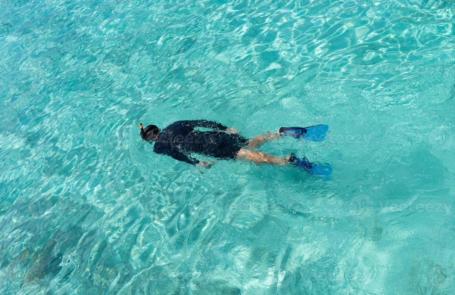 Young woman snorkeling in tropical water photo