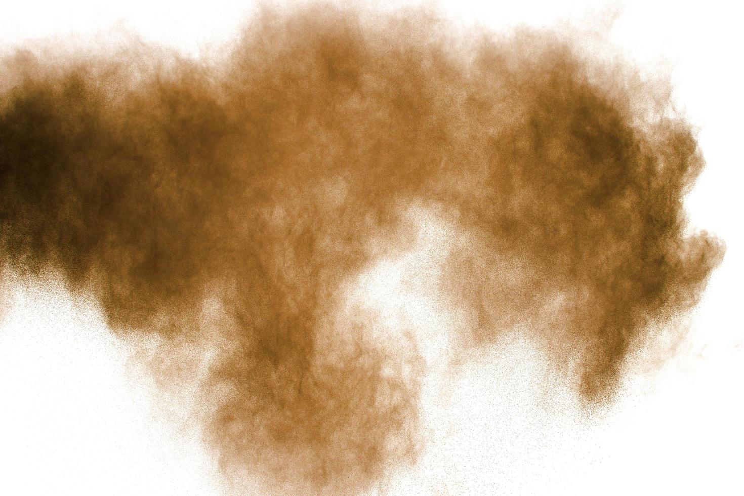 Freeze motion of brown dust explosion. Stopping the movement of brown powder. Explosive brown powder on white background. photo