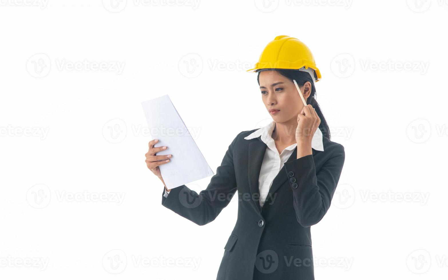 Young engineer woman wear black suit and yellow safety helmet holding note on isolated white background. photo