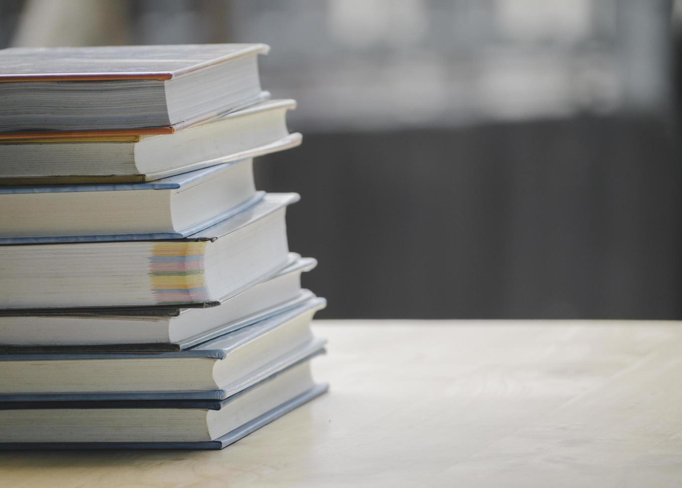 A simple composition of many books, stack or pile of books on wooden table, one of them open with copy space. photo