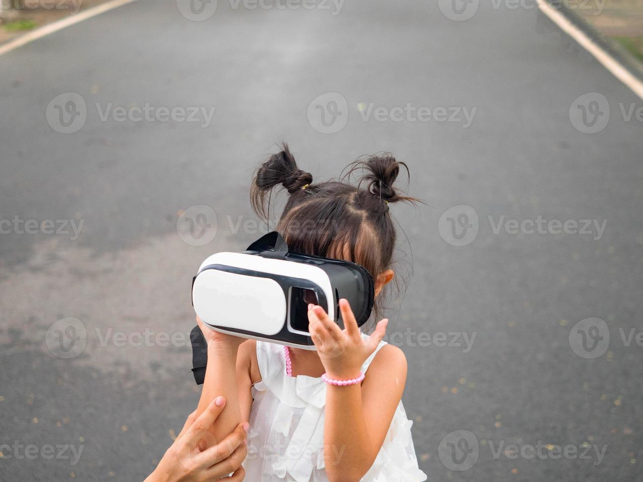 al aire libre parque verde jardín público niña niño bebé mujer hembra vestir rojo simulador auriculares realidad virtual tecnología digital vídeo cibernético red medios información datos análisis entretenimiento pantalla foto