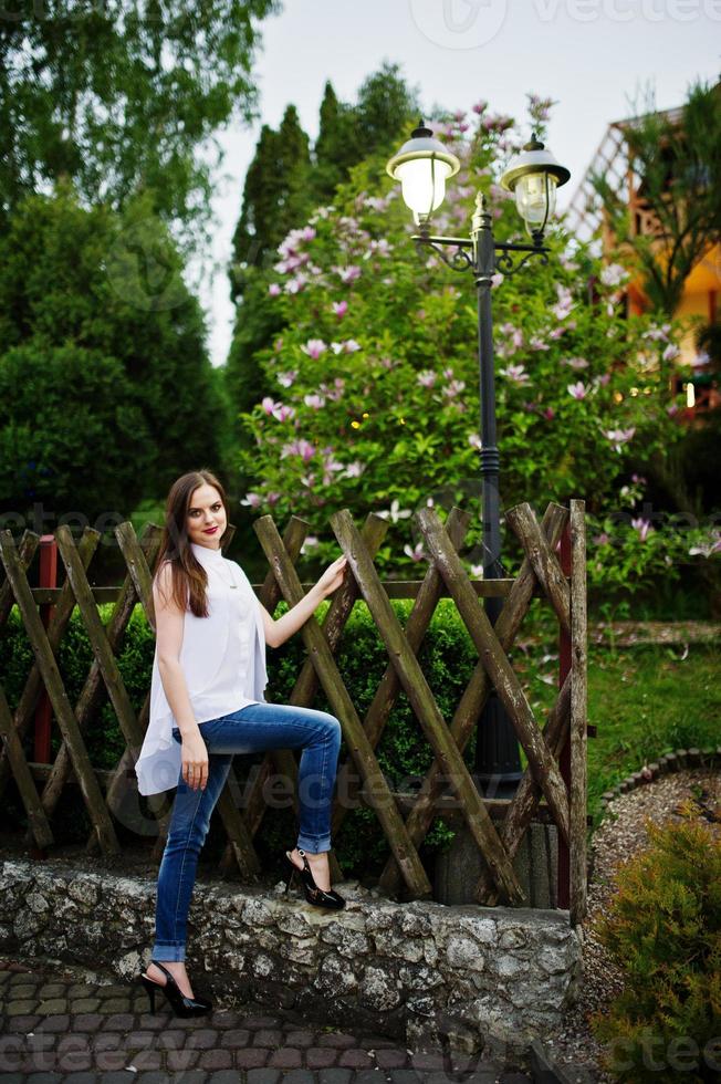 fabulosa dama de honor con jeans y camiseta blanca posando afuera en la despedida de soltera. foto