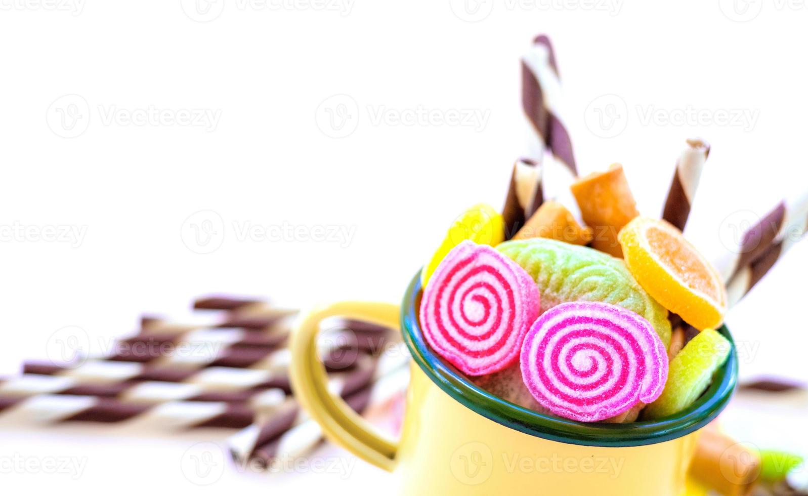 dulces coloridos y caramelos de azúcar en un fondo blanco foto
