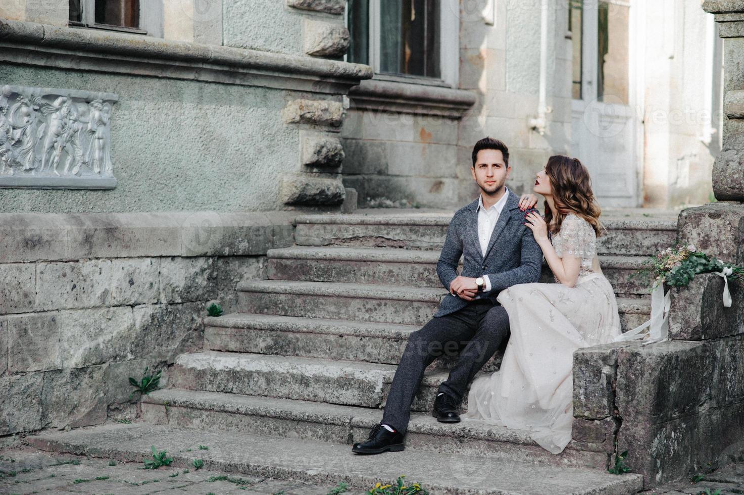 Beautiful wedding couple outside the castle on the stairs photo