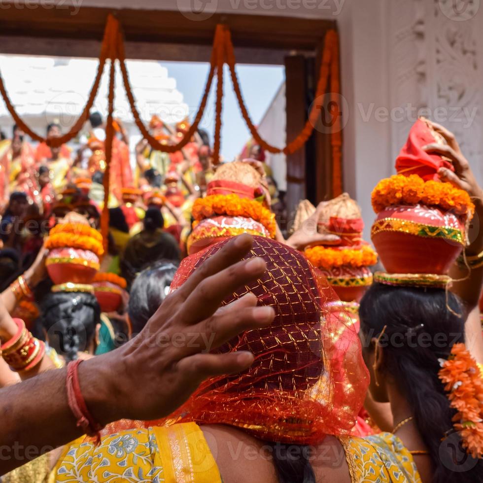 Women with Kalash on head during Jagannath Temple Mangal Kalash Yatra, Indian Hindu devotees carry earthen pots containing sacred water with a coconut on top photo
