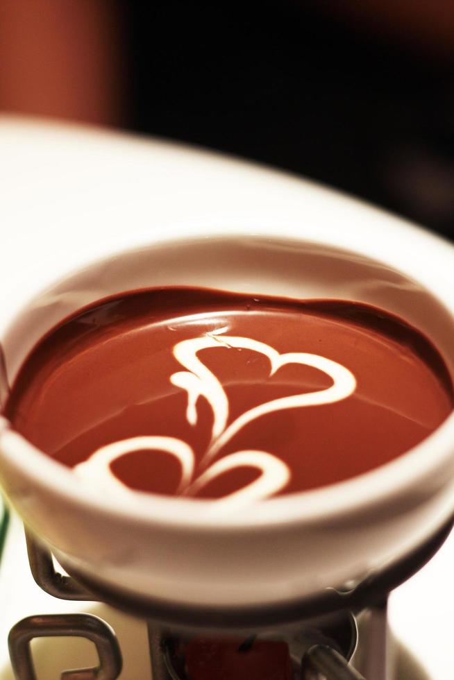 chocolate caliente con forma de corazón de crema blanca foto