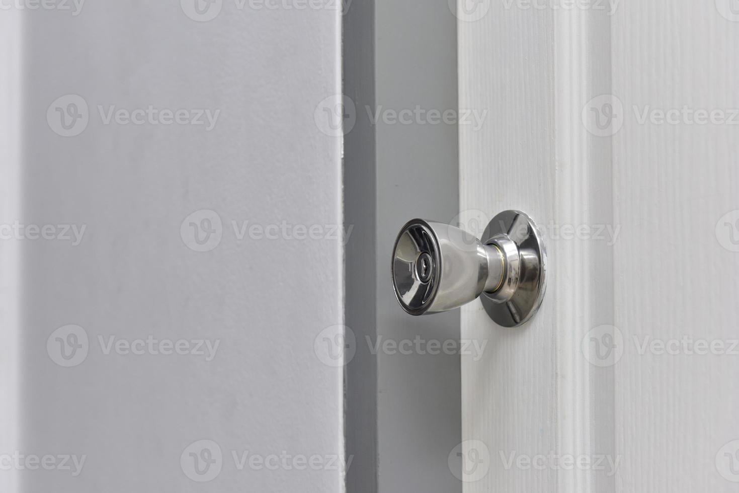 Stainless steel knob with white house door. photo