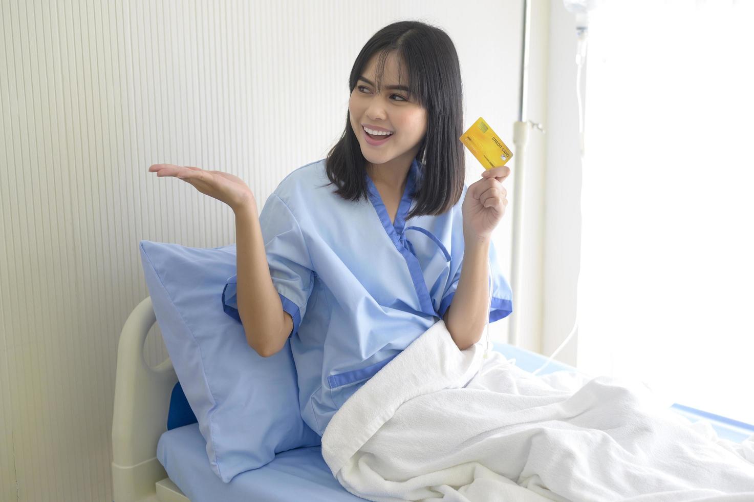 A young patient woman is holding credit card , admitting in hospital , Health care  concept photo