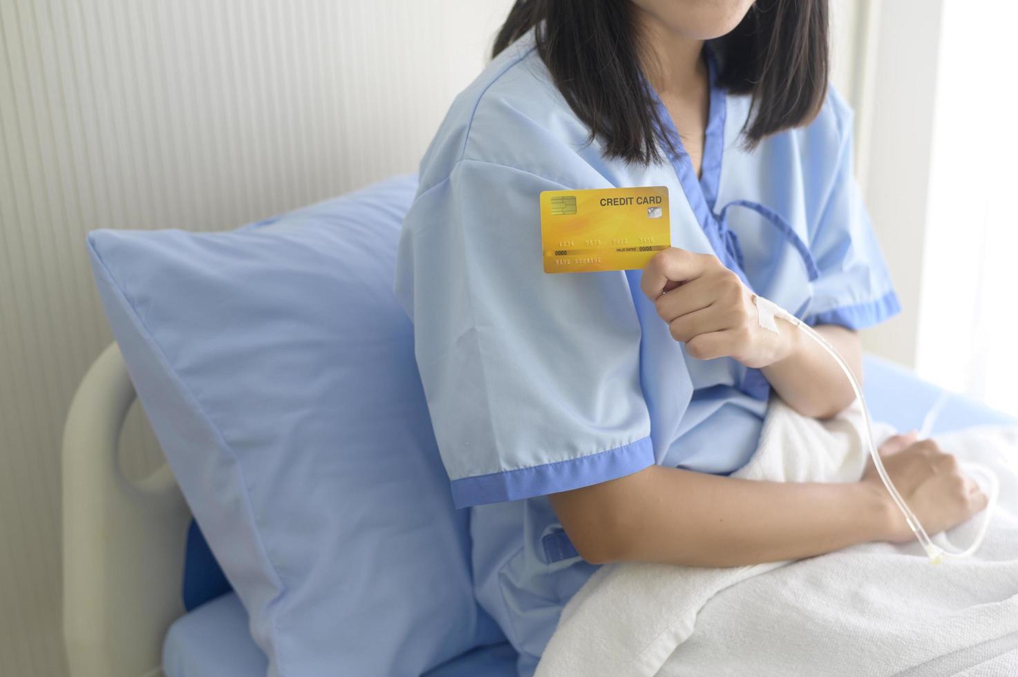 A young patient woman is holding credit card , admitting in hospital , Health care  concept photo