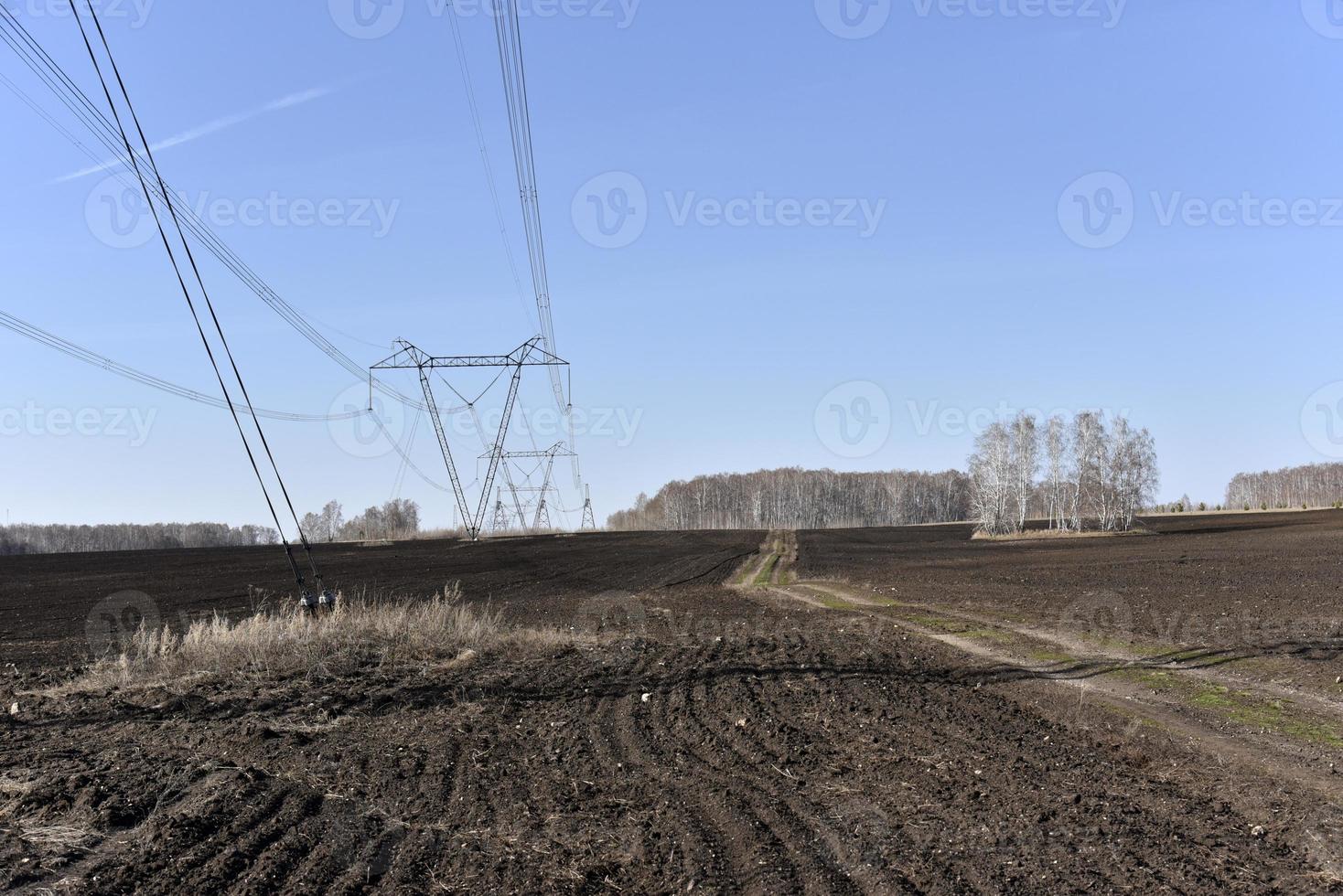 Ultra-high voltage power line in the field in spring in Russia photo