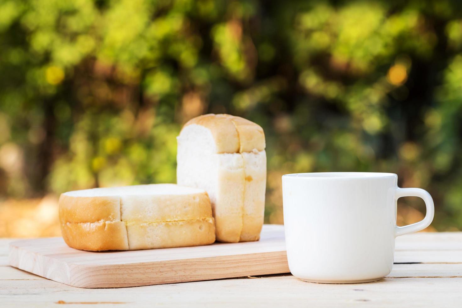 Coffee cup and bread on wooden floor photo