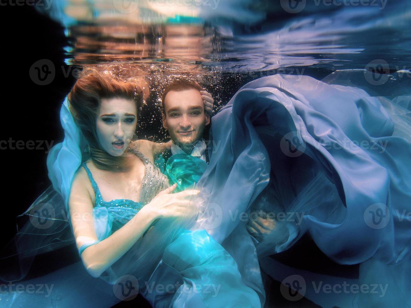 beautiful couple dancing underwater in the swimming pool photo