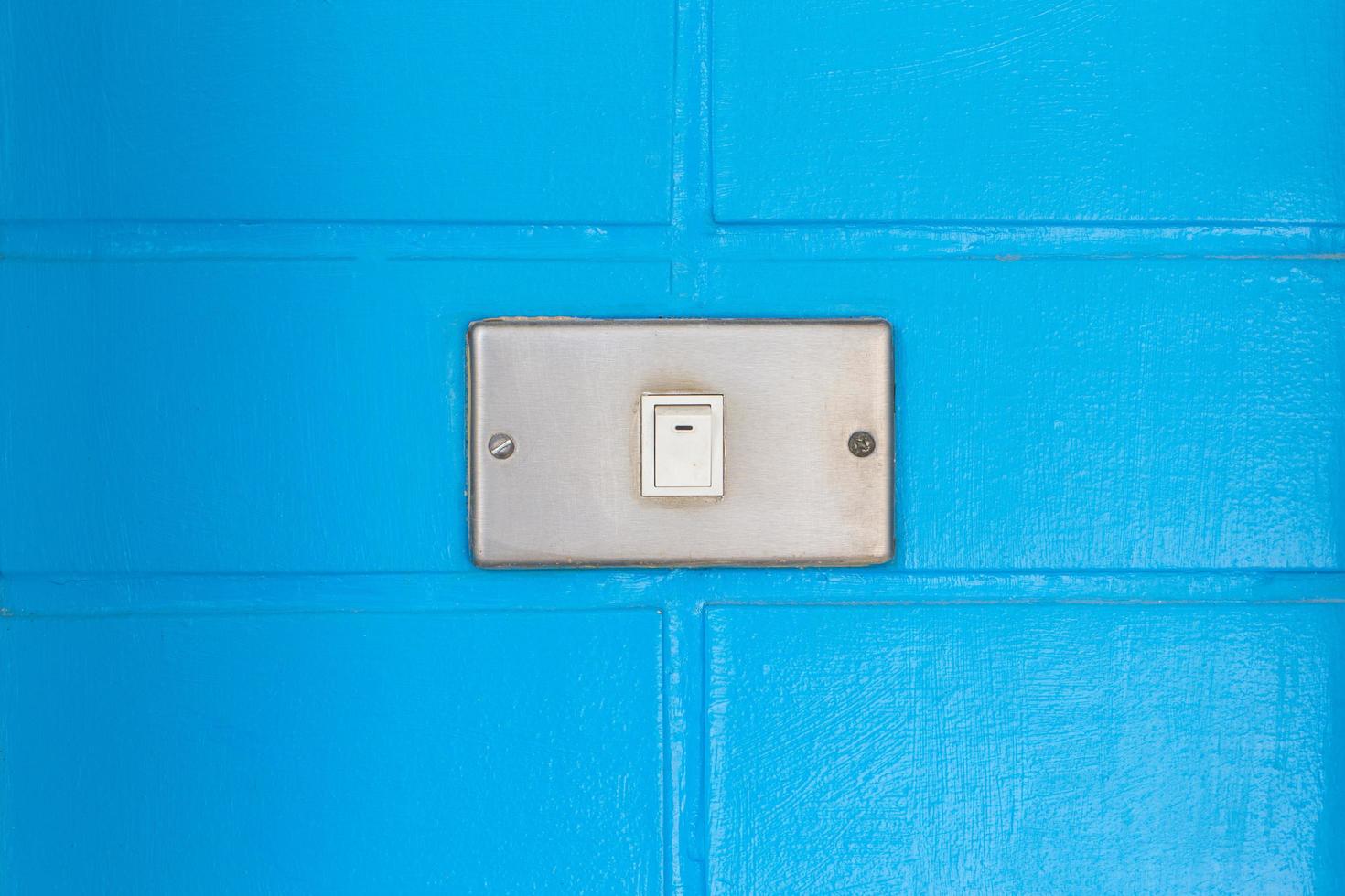 Old white switch on the bue wall photo