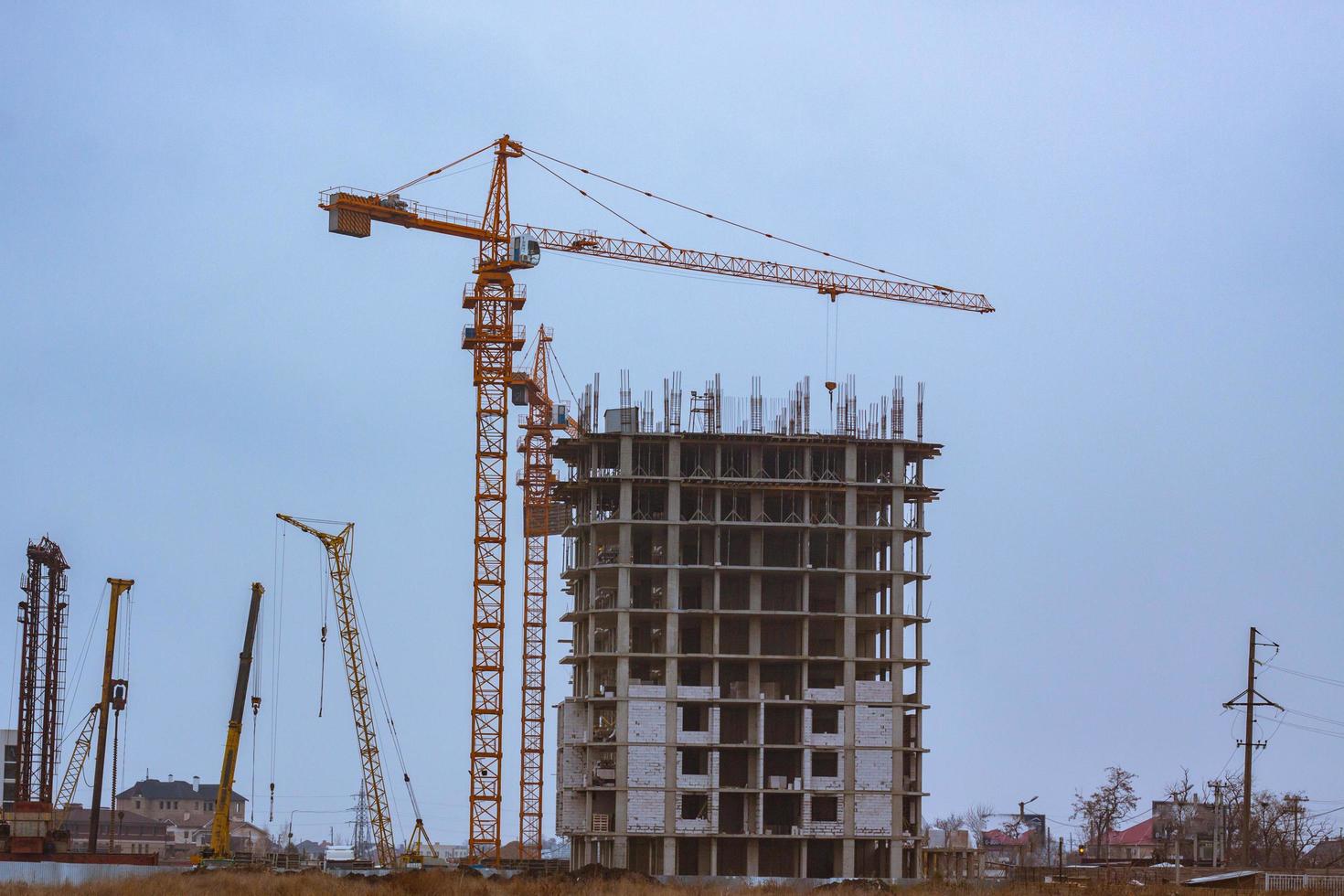 Concrete building in progress with cranes photo