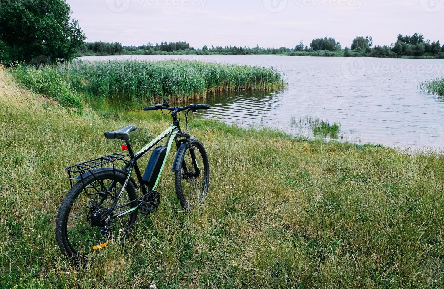 E-bike in the park in summer day. The view of the e motor and power battery. photo