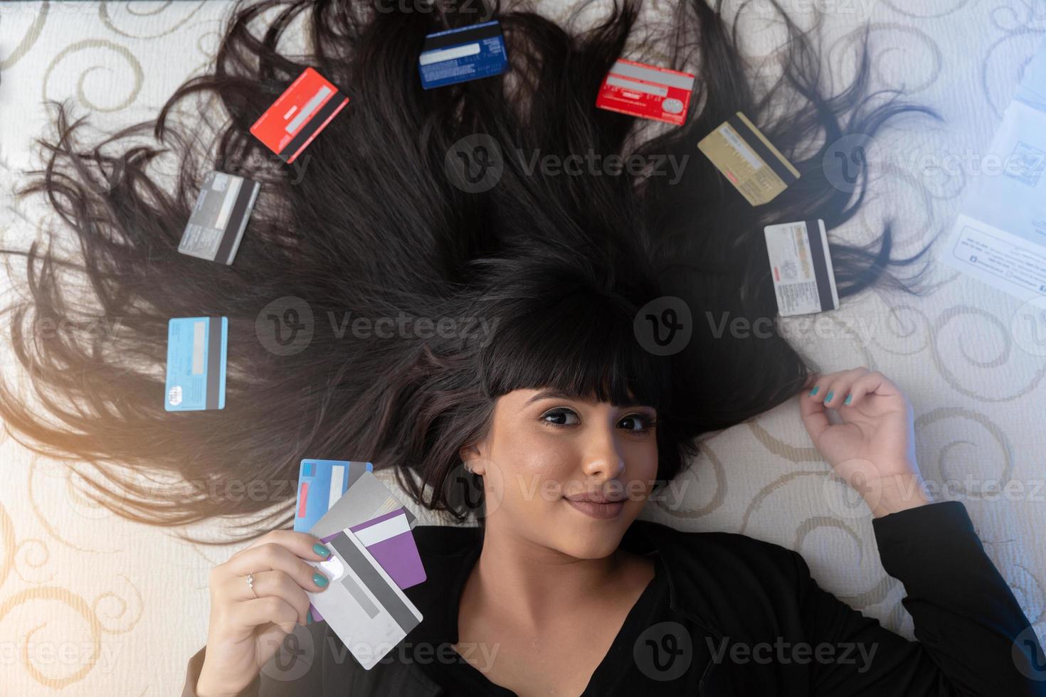 Beautiful woman with multiple credit cards on the bed. Plastic money, electronic money and digital money will change the global marketing in the near future. Concept of rich woman. photo