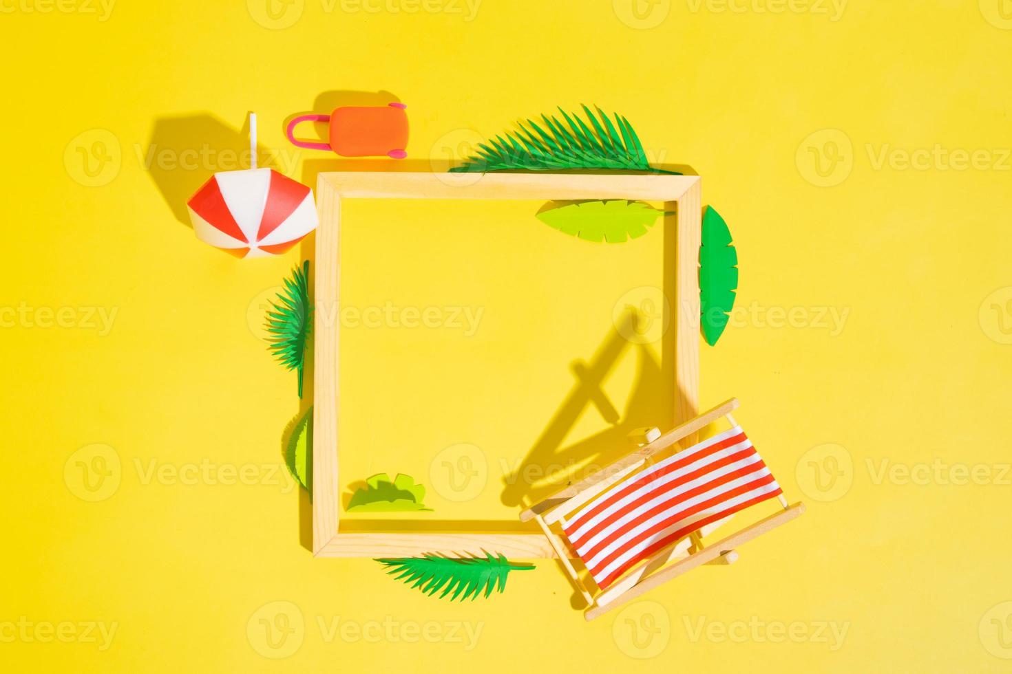 Wooden frame with beach chair and umbrella and tropical leaves with copy space top view photo