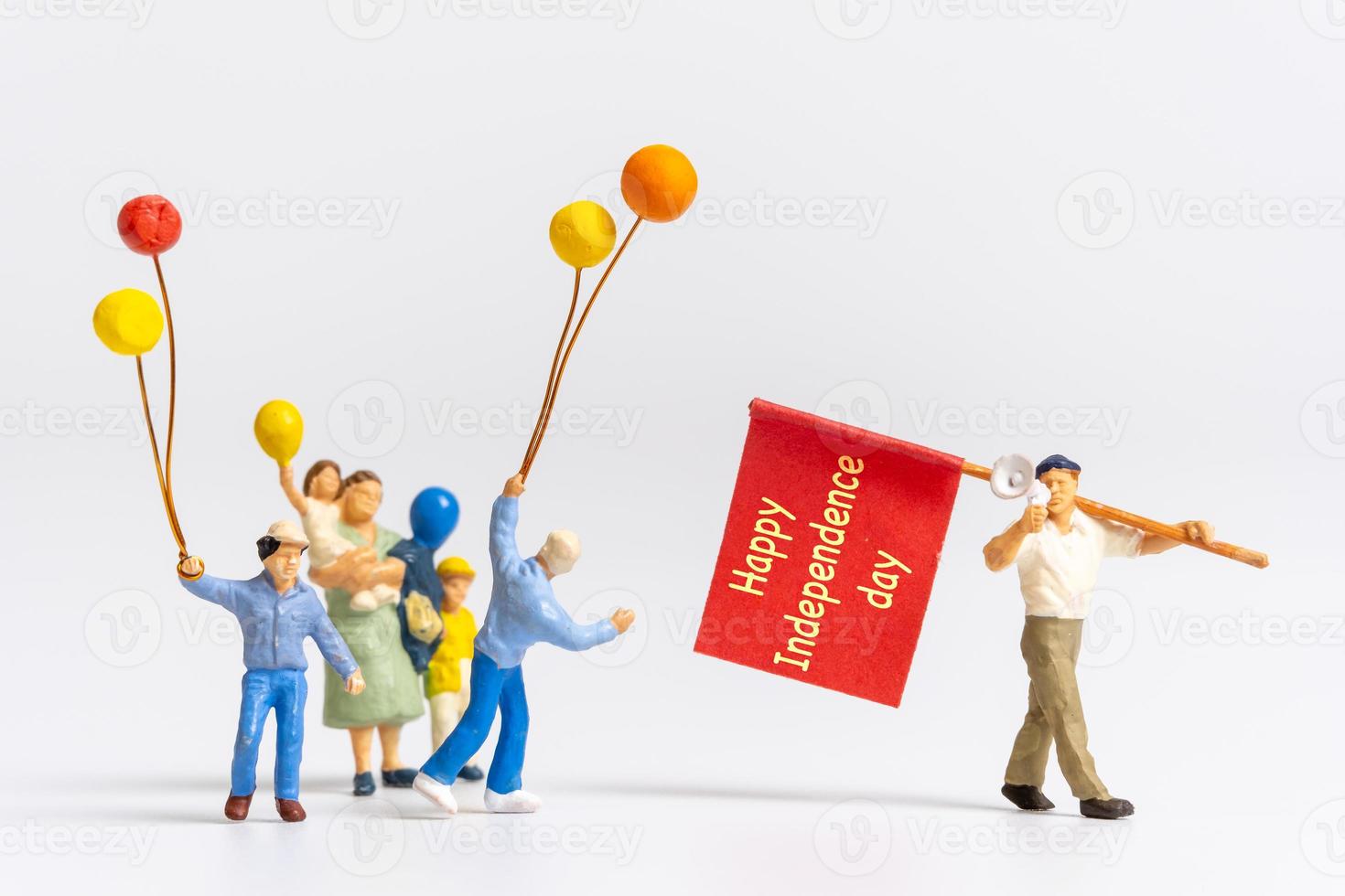 Miniature people holding flags with word Happy Independence day photo