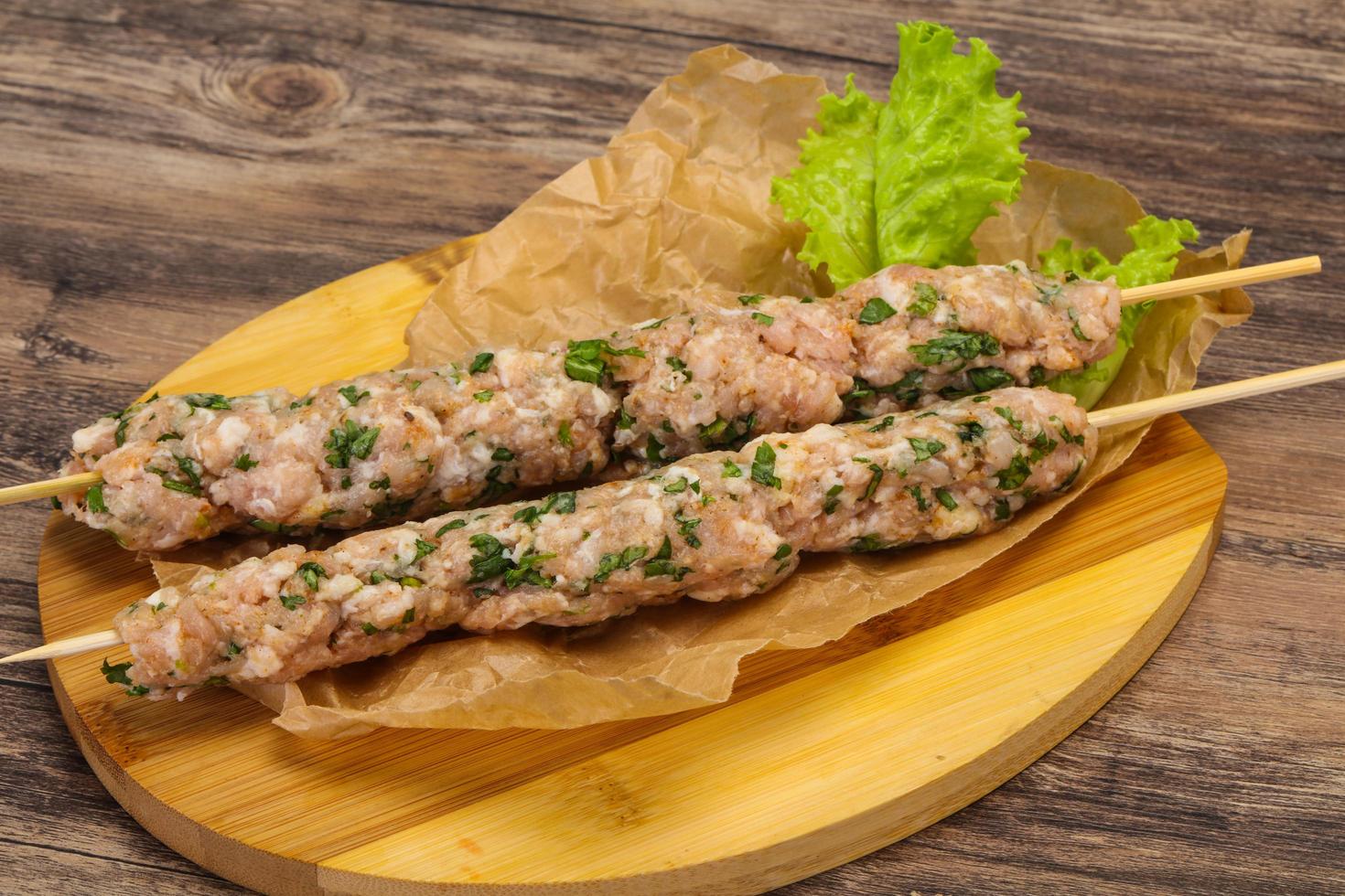 Raw minced pork skewer kebab for grill photo