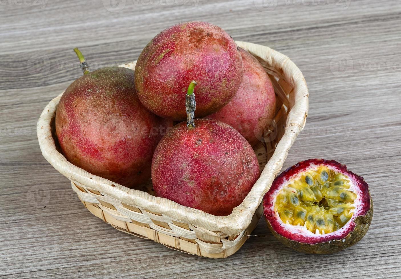 Fresh tropical fruit - Maracuja in a basket on wooden background photo