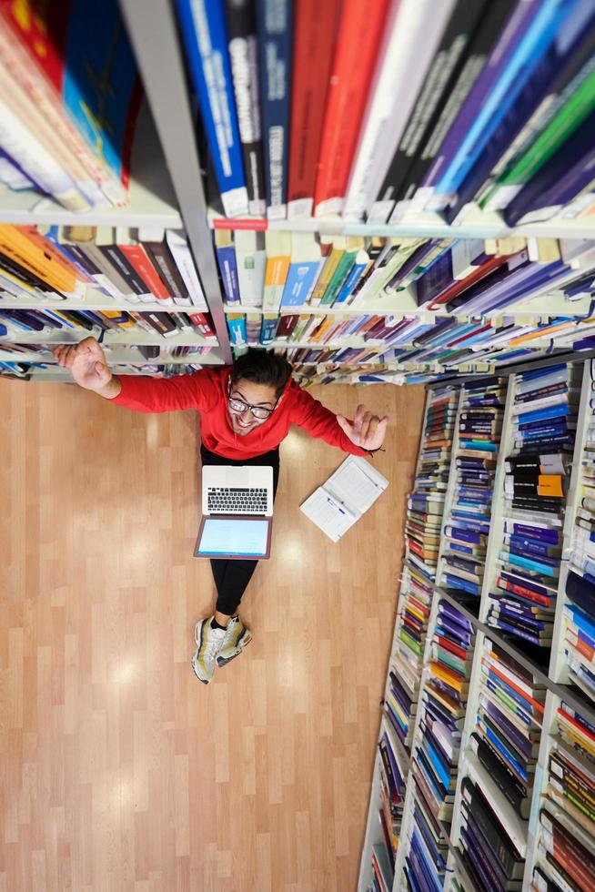 los estudiantes usan un cuaderno, una computadora portátil y una biblioteca escolar foto