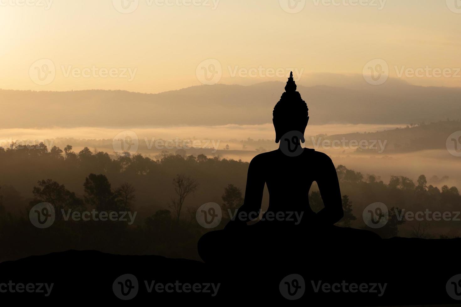Silhouette Buddha on golden sunset background. photo
