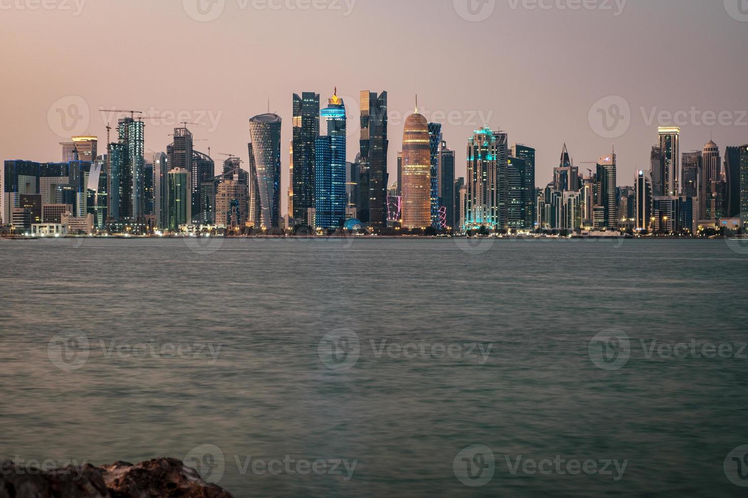 Doha Qatar skyline at night showing skyscrapers lights reflected in the Arabic gulf photo