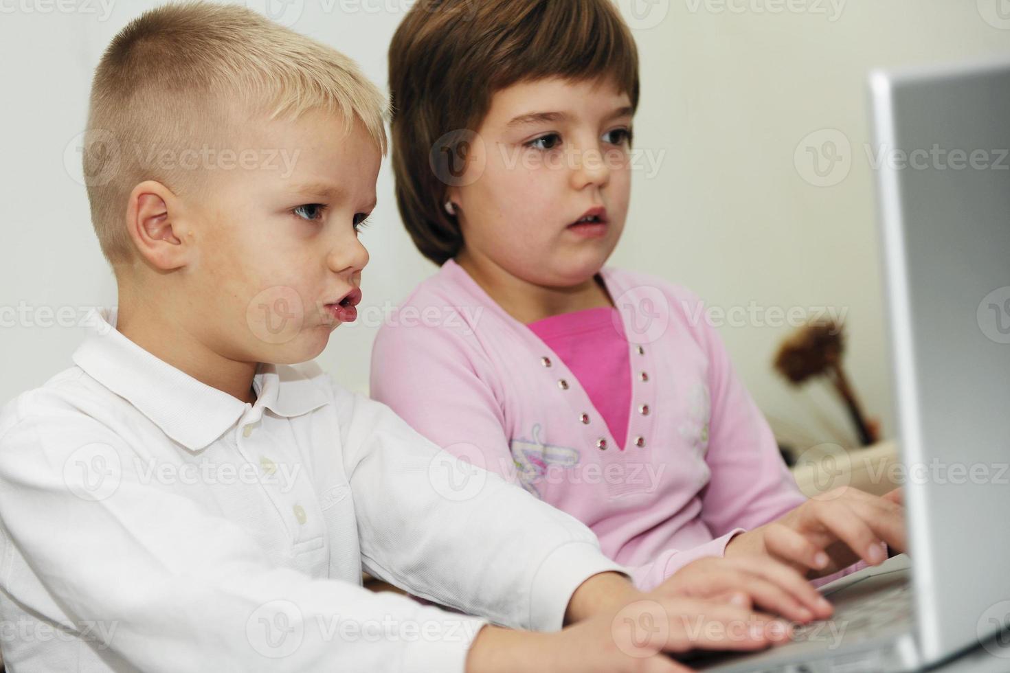 childrens have fun and playing games on laptop computer photo