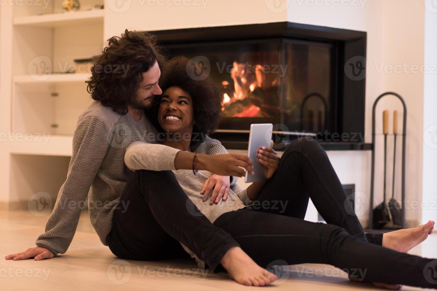 multiethnic couple using tablet computer on the floor photo