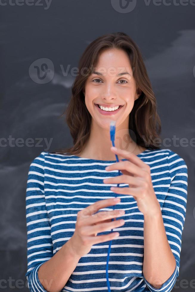 woman holding a internet cable in front of chalk drawing board photo
