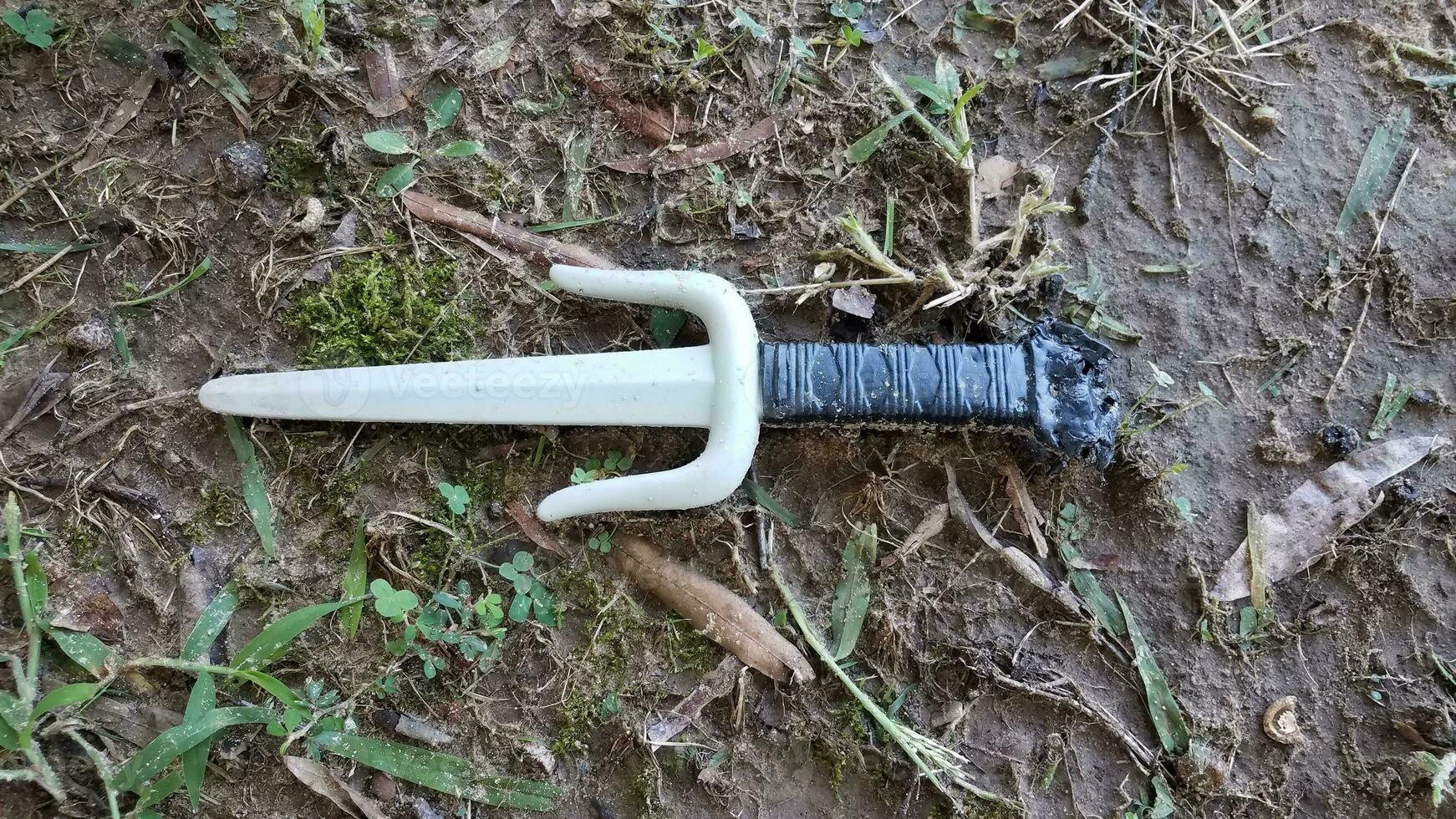 plastic martial arts sai weapon on ground or lawn photo