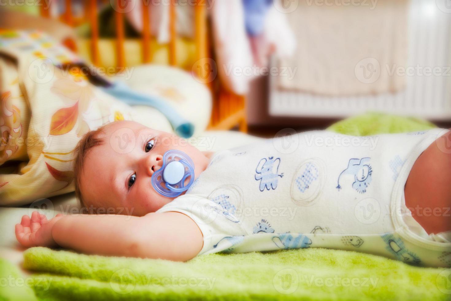 A baby waiting for changing his napkin photo