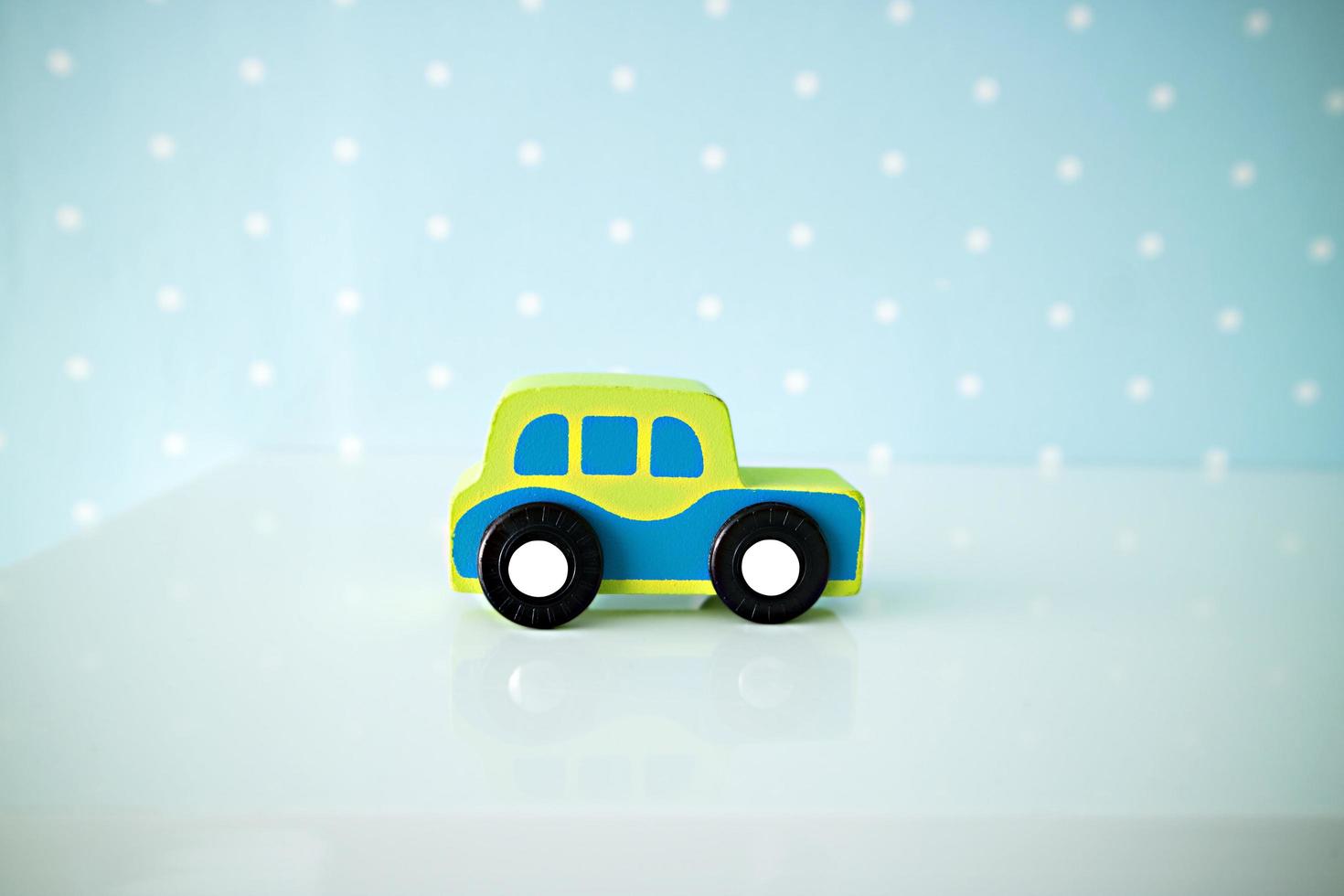 Wooden cars toys on blue polka dot background. photo