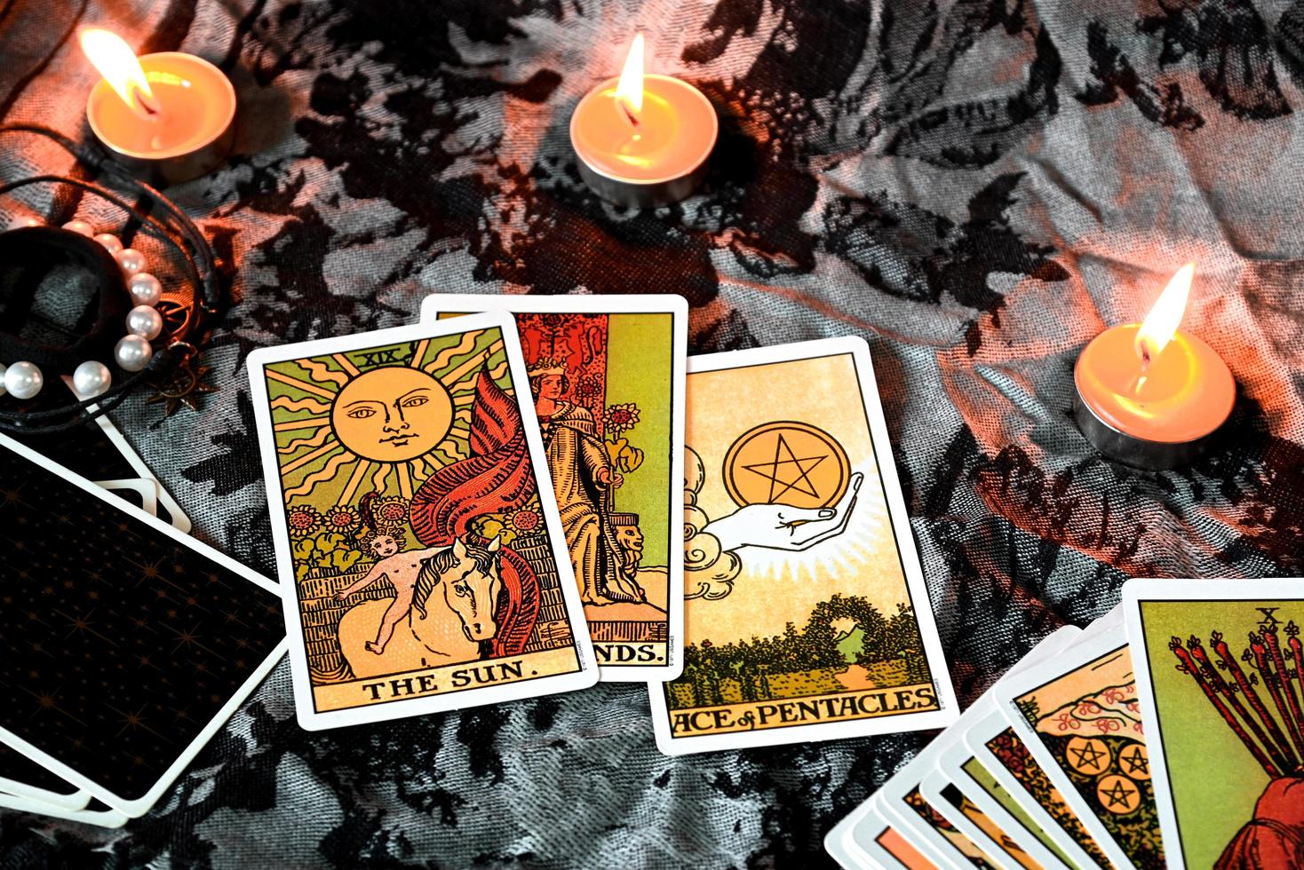 Tarot reading with tarot card background and candlelight on the table for Astrology Occult Magic Spiritual Horoscopes and Palm reading fortune teller tarot reader photo