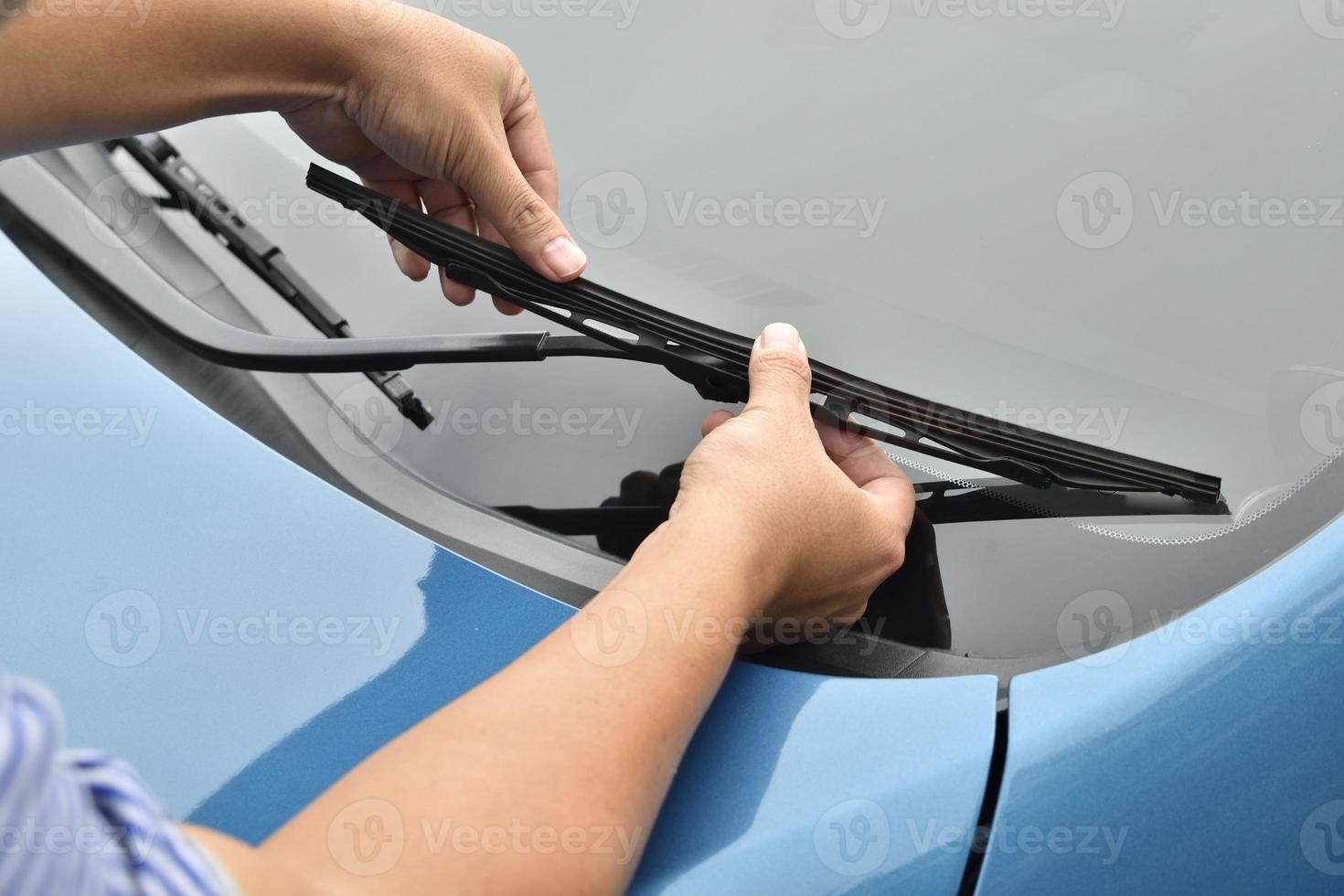 man hand picking up windscreen wiper photo
