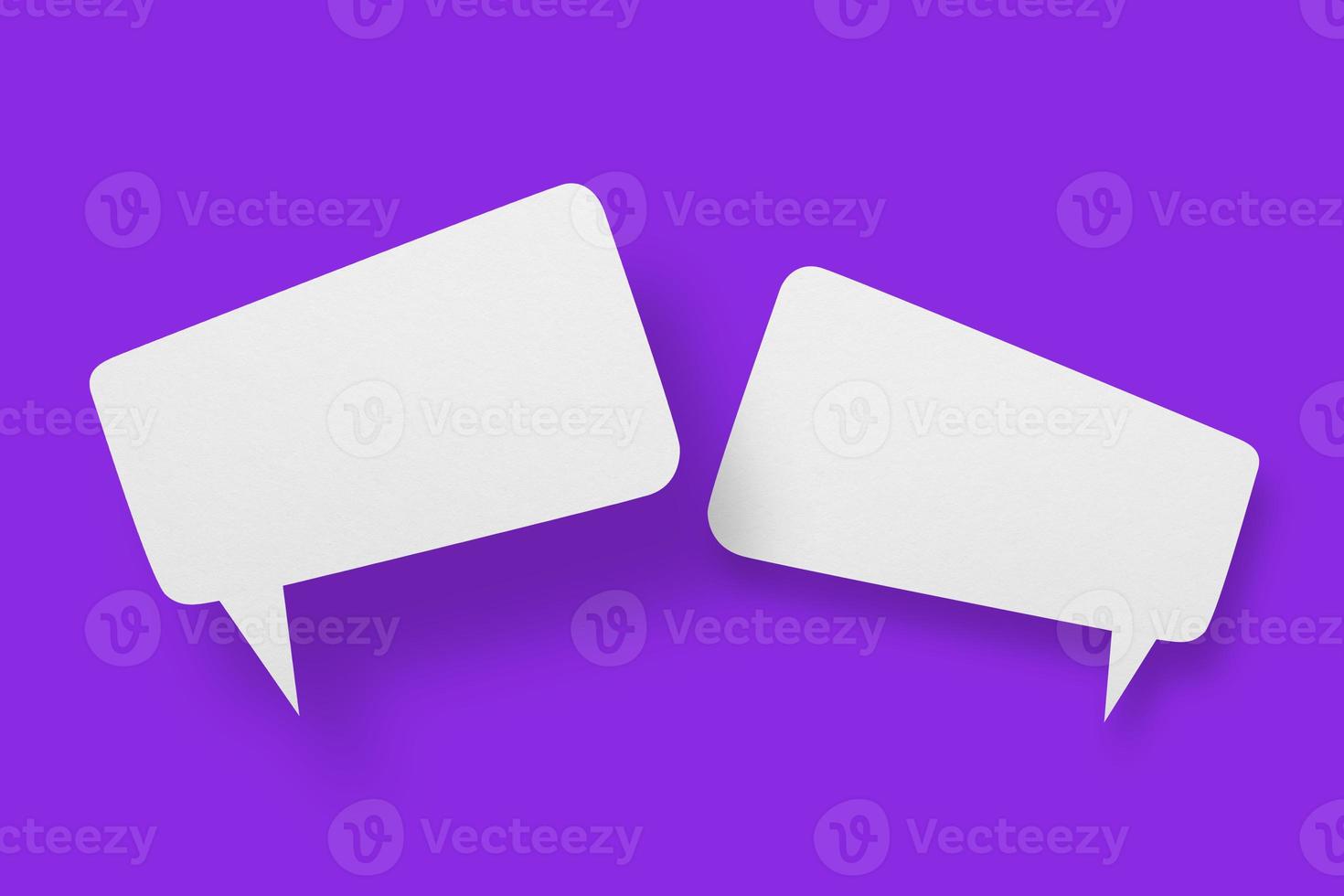 White paper in the shape of speech bubbles against a purple background. Communication bubbles. photo