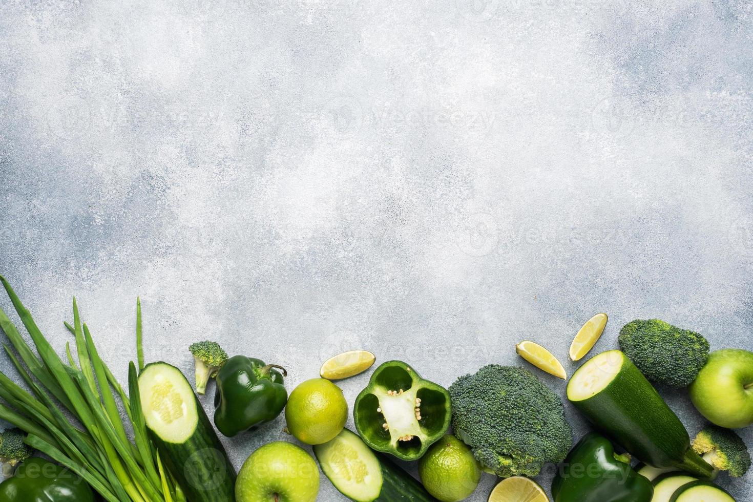 Frame Fresh green vegetables and herbs on a grey concrete background. Copy space. photo