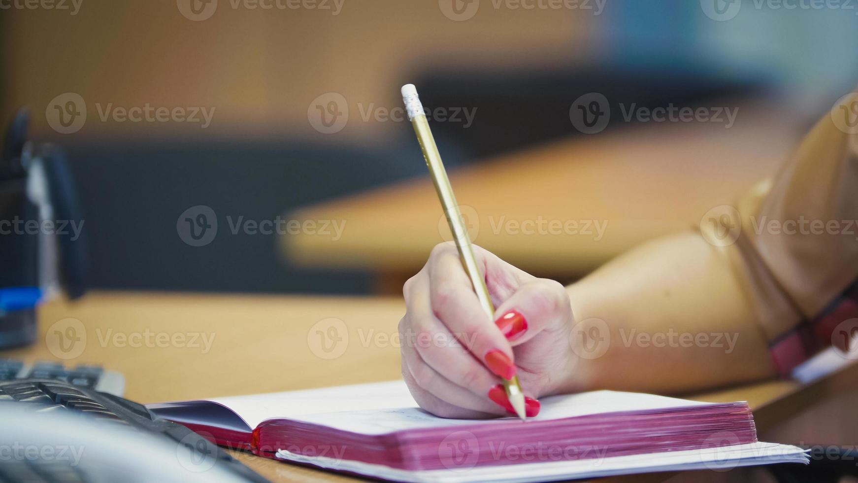 gestos con las manos de la gerente de la oficina cuando habla por teléfono - tomando notas en el bloc de notas, cerrar foto