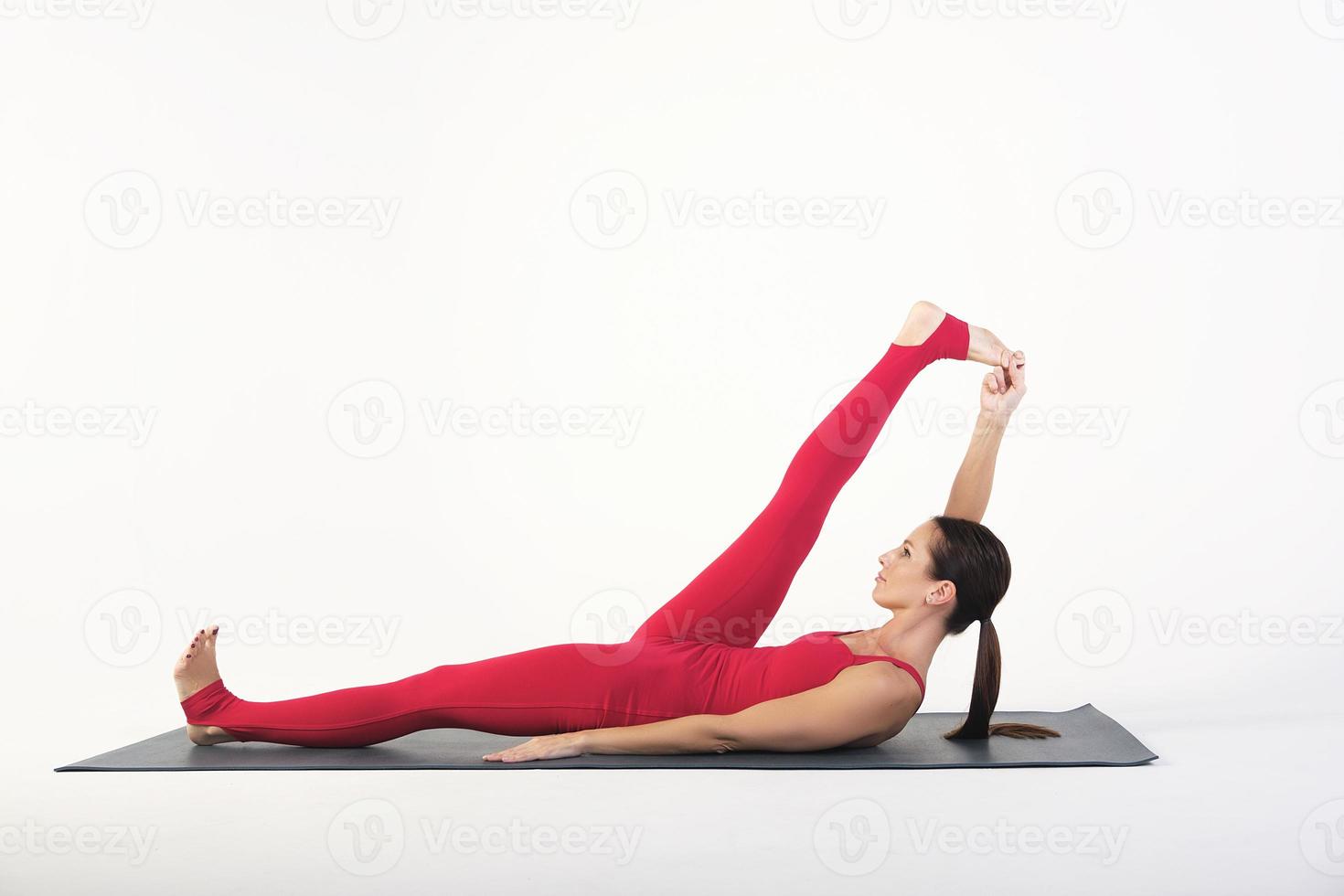 a charming girl demonstrates stretching and yoga asanas in a photo studio