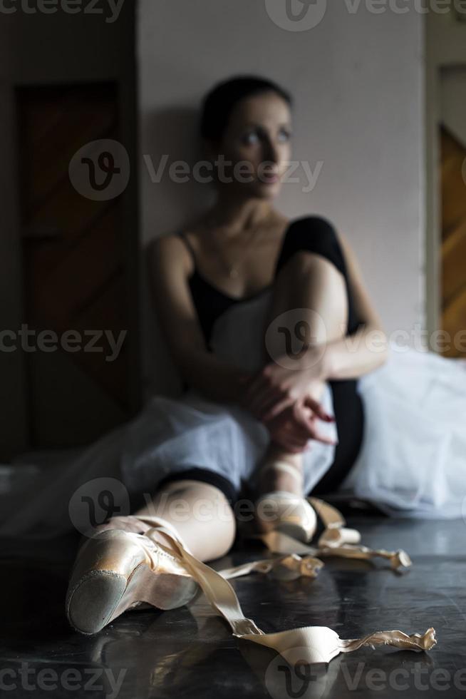 a charming ballerina in a bodysuit poses ballet elements in a headdress in a photo studio