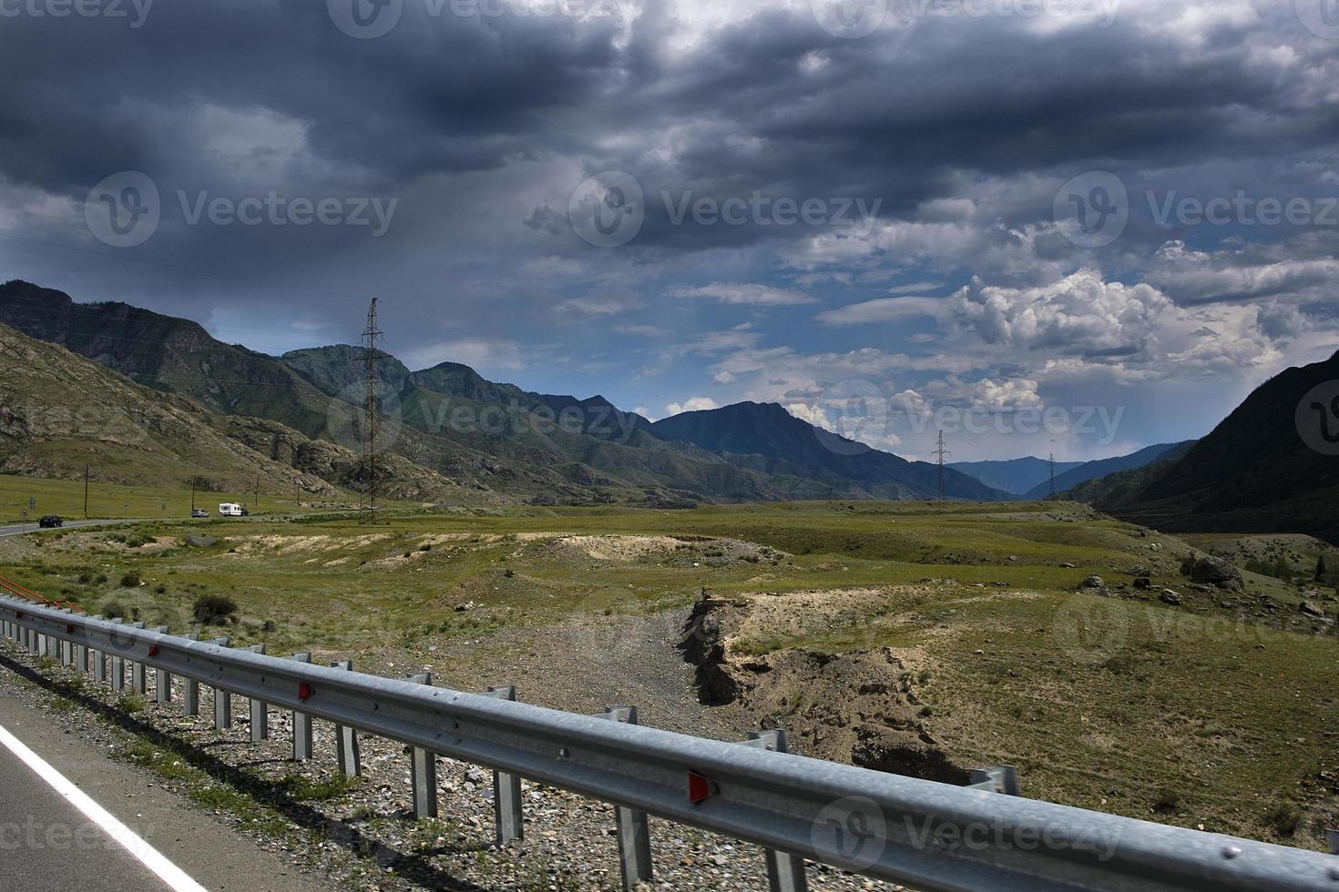 ribbon of the road among the slopes of the mountains on the expanses of Altai on a summer day photo